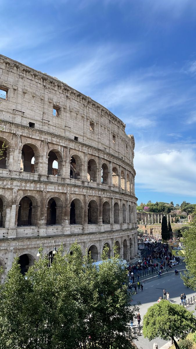 the colossion in rome, italy with tourists walking around and looking at it