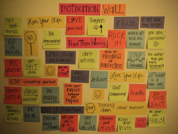 a bulletin board with words written on it and sticky notes attached to the wall above it