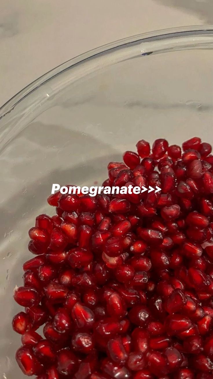 pomegranate in a glass bowl with the word pomegranate above it