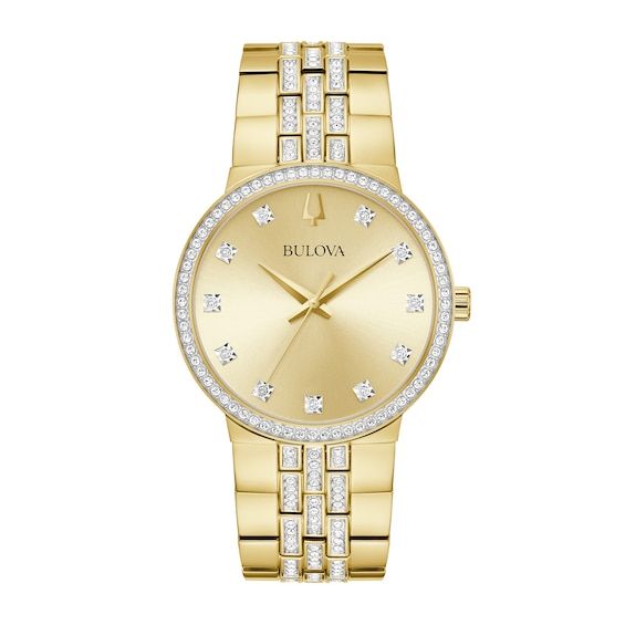 Speak to his sophisticated yet modern taste in style with this men's Bulova crystal accent gold-toned watch and cross pendant box set. The champagne sunray dial showcases gold-toned hands, eleven crystal hour markers and the signature tuning fork logo at 12 o'clock. 40.0mm gold-toned ion-plated stainless steel case with mineral crystal and a crystal-lined bezel Japanese quartz movement keeps accurate time. The gold-toned ion-plated stainless steel bracelet features triple rows of crystal-adorned center links and secures with a push-button fold-over clasp. Water resistant to 30 meters, this watch includes a 3-year limited manufacturer warranty. The flared-edge cross pendant shines with a crystal-lined center and suspends along a 24.0-inch box chain that secures with a lobster claw clasp. We Classic Gold Diamond Watch, Classic Gold Diamond Watch With Brilliant Cut, Classic Yellow Gold Diamond Watch With Polished Finish, Gold Watches With Diamond Accents For Formal Occasions, Classic Gold Watches With Diamond Accents, Yellow Gold Watches With Diamond Accents For Gift, Yellow Gold Watches With Diamond Accents As Gift, Formal Gold Watches With Diamond Accents, Luxury Gold Diamond Watch With Brilliant Cut