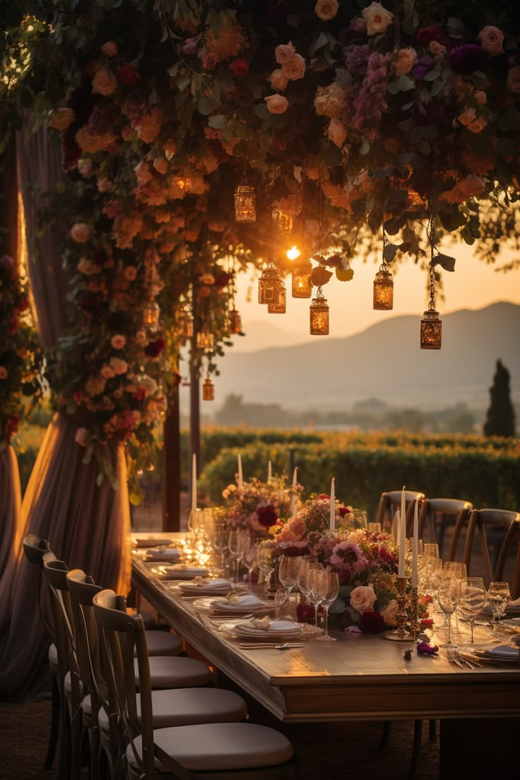 an outdoor dining table set with flowers and candles