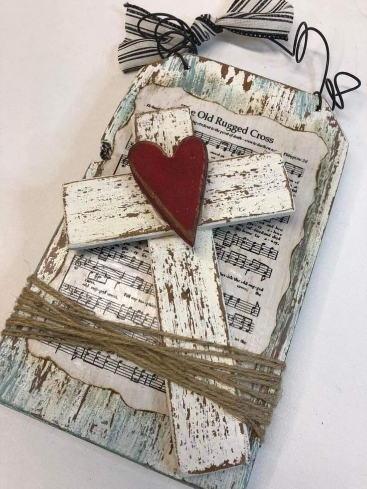 a heart is placed on top of some old sheet music sheets with string attached to it