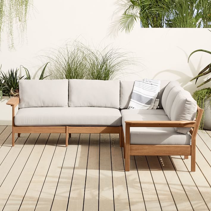 a couch sitting on top of a wooden floor next to potted plants