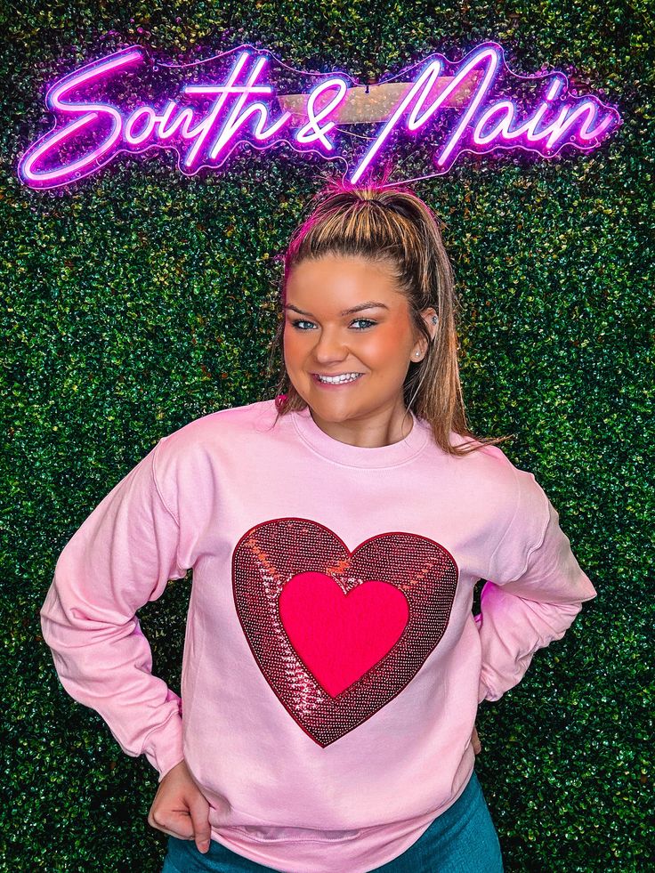 Indulge in the Valentine's spirit with our cute Red Sequin Heart Sweatshirt. The chenille and sequin accents add a stylish touch to this sweatshirt, making it the perfect choice for the season of love. Available in classic light pink, with a charming red and hot pink heart to complete the look. Unisex sizing and fit Pictured: Light Pink SPECIAL CARE - WASHING INSTRUCTIONS: Hand washing and air drying are always best for these items. Wash on delicate, cold, and inside out. Always air dry to preve Bag Patches, Sequined Sweatshirt, Heart Sweatshirt, Sequin Design, Converse With Heart, Red Sequin, Cute Sweatshirts, Cozy Sweatshirts, Spread Love