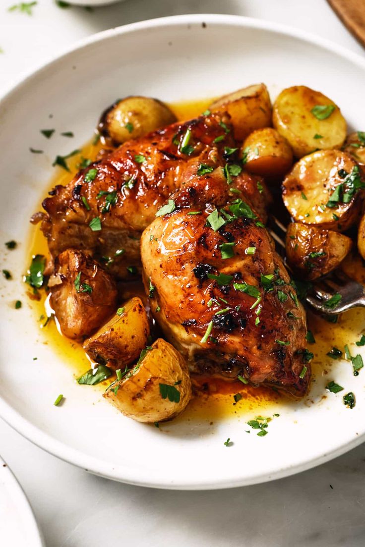 a white plate topped with chicken and potatoes