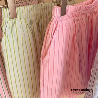 three pairs of pink and green striped shorts hanging from hooks