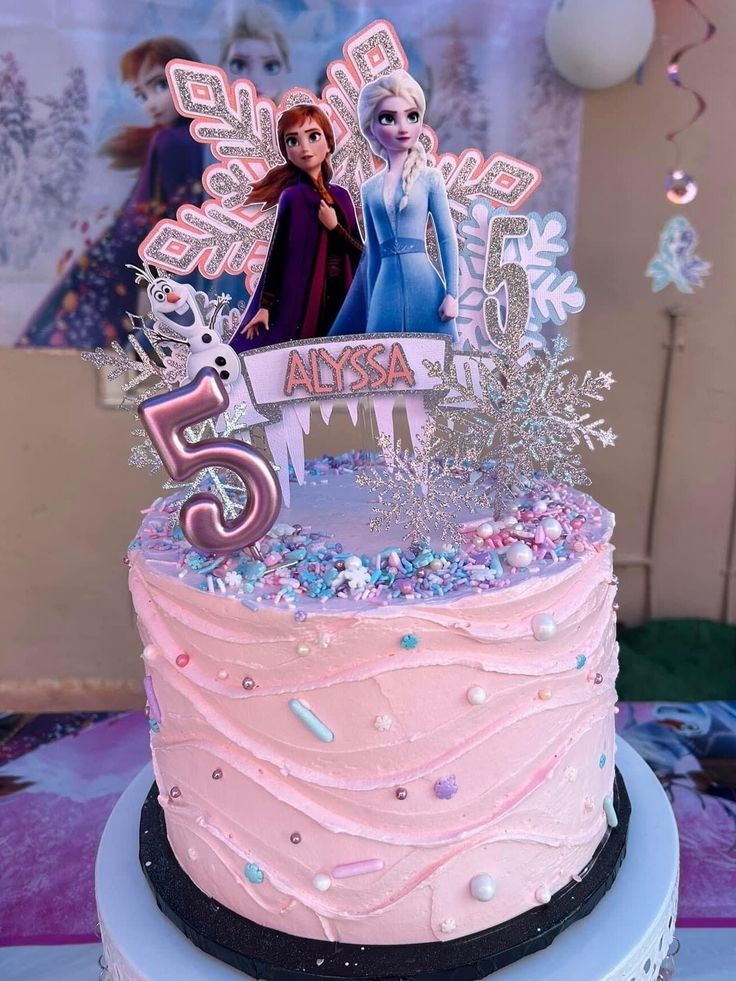 a frozen princess birthday cake with pink frosting