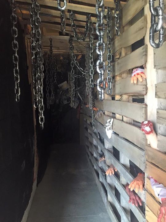 the inside of a building with chains hanging from it's sides and hands on the wall