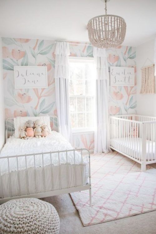 a baby's room with floral wallpaper and white crib in the corner