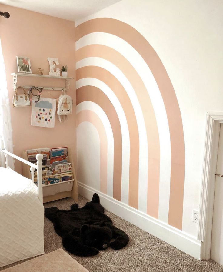 a child's room with pink and white stripes painted on the wall, carpeted floor