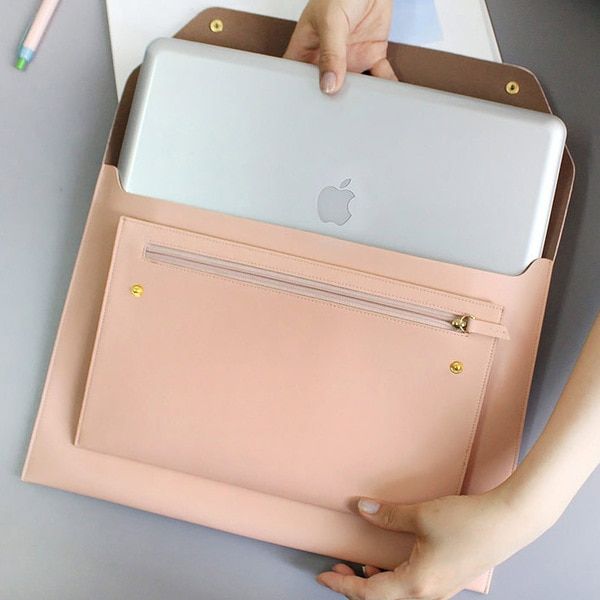 a person is holding an apple laptop in their hand and it's inside the case