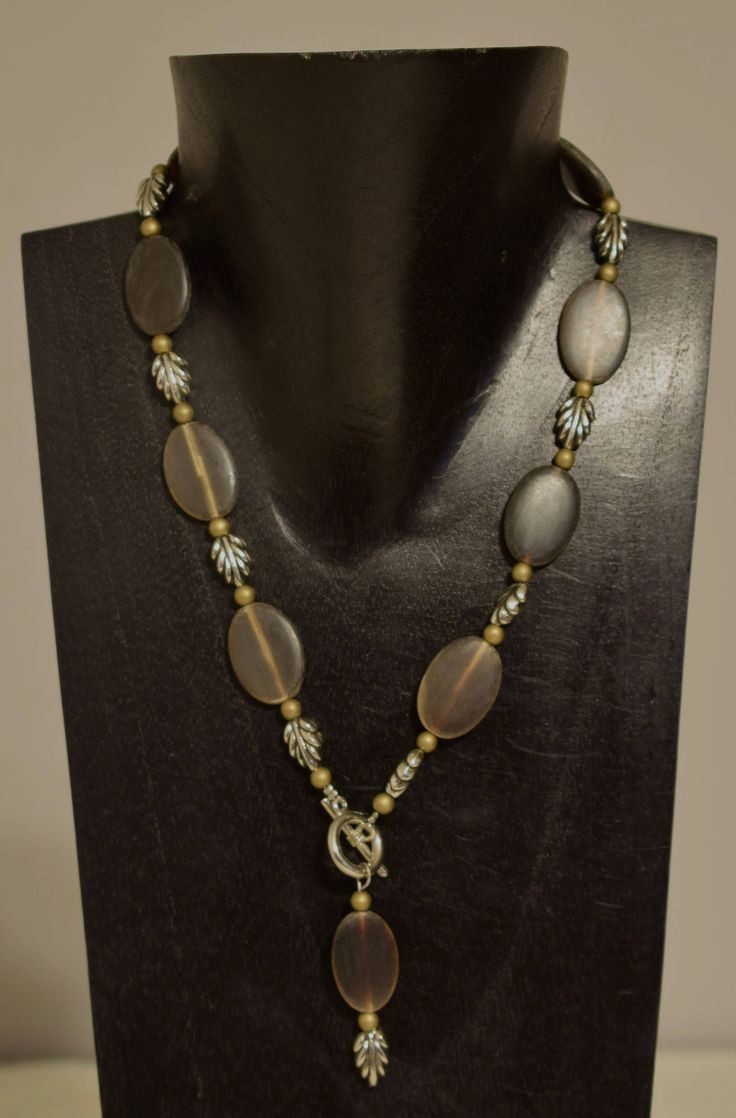 This lovely Handmade Oval Horn Pendant Front Toggle Necklace with Silver Leaf Beads and Bronze Beads all strung on wire with  a with a silver toggle clasp. A truly a wonderful necklace that will compliment any outfit, is lightweight and comfortable  to wear.  A great gift to give that special someone. Necklace with Pendant 22 Inches Long Beads 19.5 Inches Long Brown Horn  25mm Long 18mm Wide Silver Leaves 12mm Long 10mm Wide Bronze Beads 4mm Round AT BACARA WE STAND BEHIND ALL OF OUR MERCHANDISE.  FULL MONEY BACK GUARANTEE WILL BE PROVIDED FOR DISSATISFIED CUSTOMERS. YOUR SATISFACTION IS OUR MAIN GOAL, AND WE THANK YOU FOR SHOPPING AT BACARA. A195 Horn Pendant Necklace, Cowrie Shell Necklace, Leaf Beads, Necklace With Pendant, Silver Leaves, Toggle Necklace, Horn Pendant, Shell Necklaces, Toggle Clasp