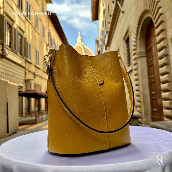 "This bag has been made of the best genuine leather by local master crafters of Florence in Italy, designed for women who only accept premium Italian quality and luxury leather bags and modern Italian fashion. . Size: Width: 27 cm / 10.75 inches Height: 19 cm / 7.50 inches Depth: 9 cm / 3.50 inches . The story of this bag : Once upon a time, in the charming city of Florence, Italy, renowned for its exquisite artistry and craftsmanship, there existed a small workshop tucked away in a cobblestone alley. This was the home of a gifted artisan named Alessio, whose passion for creating beauty out of leather was unparalleled. Alessio specialized in handcrafted leather goods, and his most prized creations were the leather clutch bags that exuded elegance and sophistication. The timeless charm of h Gold Leather Bucket Shoulder Bag, Gold Leather Bucket Bag For Office, Modern Gold Leather Bucket Bag, Yellow Rectangular Business Bag, Luxury Yellow Satchel With Large Capacity, Luxury Yellow Bucket Bag With Removable Pouch, Yellow Business Satchel Bag, Elegant Large Capacity Yellow Bag, Luxury Large Capacity Yellow Shoulder Bag