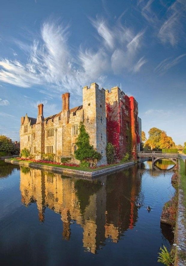 an old castle sitting on the side of a river