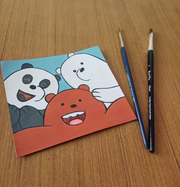 a drawing of two bears and a bear on a piece of paper next to a pencil