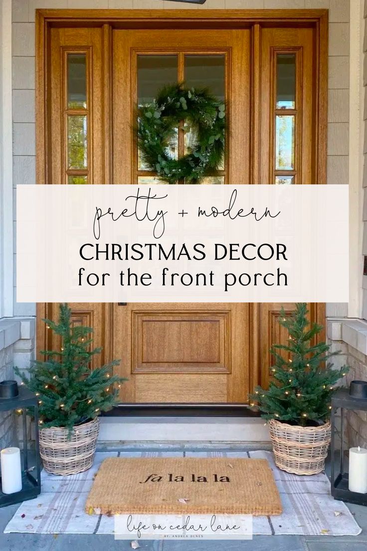 a front porch decorated for christmas with wreaths and potted trees on the doorstep