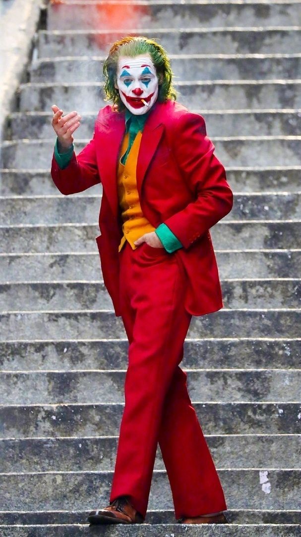 a man dressed as the joker walking down some steps