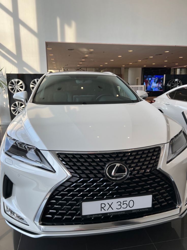 the front end of a white car in a showroom