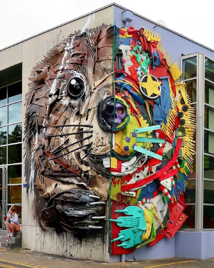 a large animal made out of different types of objects on the side of a building