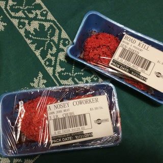 two plastic containers filled with red food on top of a green tablecloth covered floor