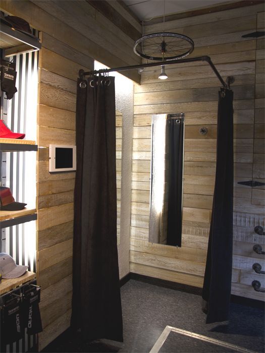 a bathroom with wooden walls and black curtains