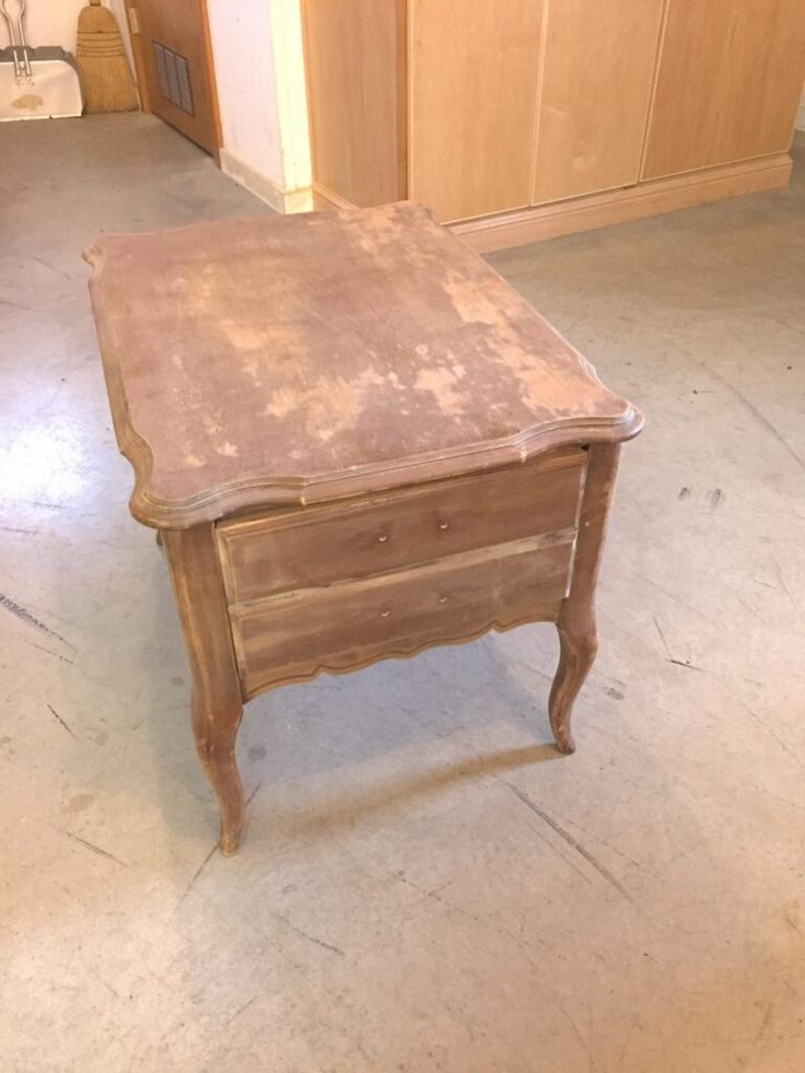 an old wooden table with the words before painted on it in front of a door