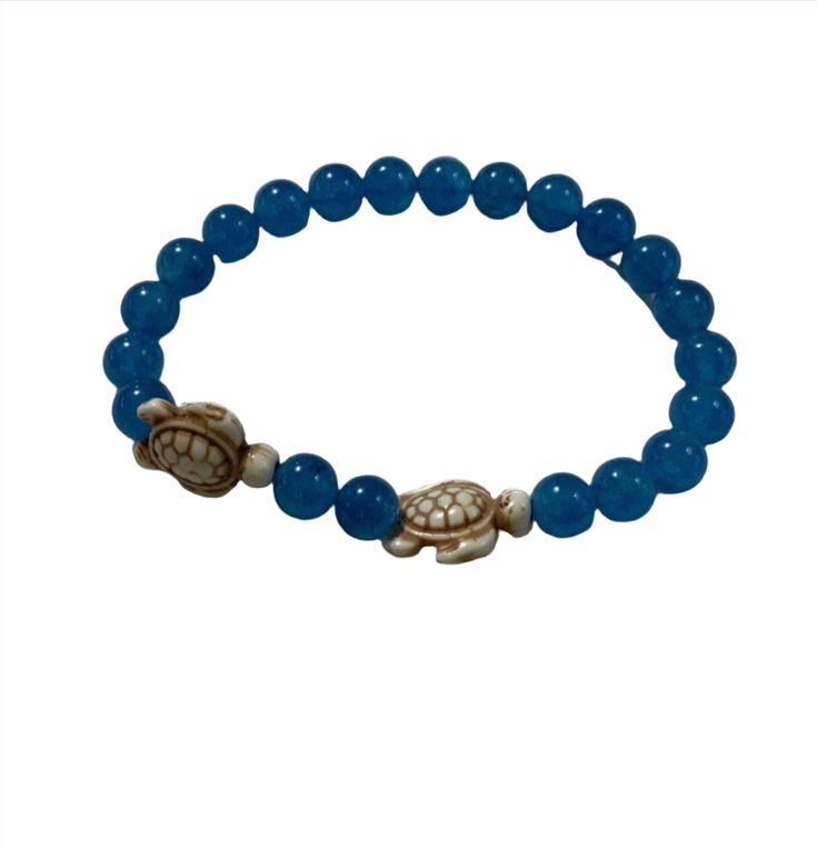 Unleash the magic of the sea with our Turtle Beaded Bracelet, a captivating piece that combines reconstituted white tortoise and enchanting cornflower blue Jade Quartzite gemstone beads. Crafted with meticulous care and strung on a resilient magic stretch cord, this bracelet embodies the spirit of the sea turtle in a design that's as alluring as it is meaningful. The large 18x14mm reconstituted white tortoise centerpiece adds a touch of timeless elegance, while the 8mm cornflower blue Jade Quartzite beads infuse a sense of serenity and balance. Embrace the turtle's symbolism of longevity and wisdom while enjoying the beauty of this stunning bracelet. This piece is more than just jewelry; it's a statement of your love for turtles and your connection to the tranquil depths of the sea. Dive i Turtle Symbolism, Blue Corn Flower, Corn Flower Blue, Purple Jasper, Bracelet Size Chart, Turtle Bracelet, Blue Jade, Turtle Necklace, Turtle Earrings