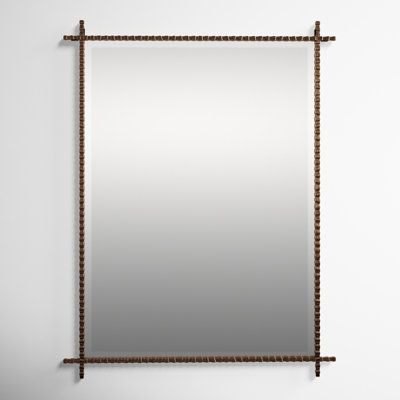 a mirror hanging on the wall with chains attached to it's sides and an iron frame