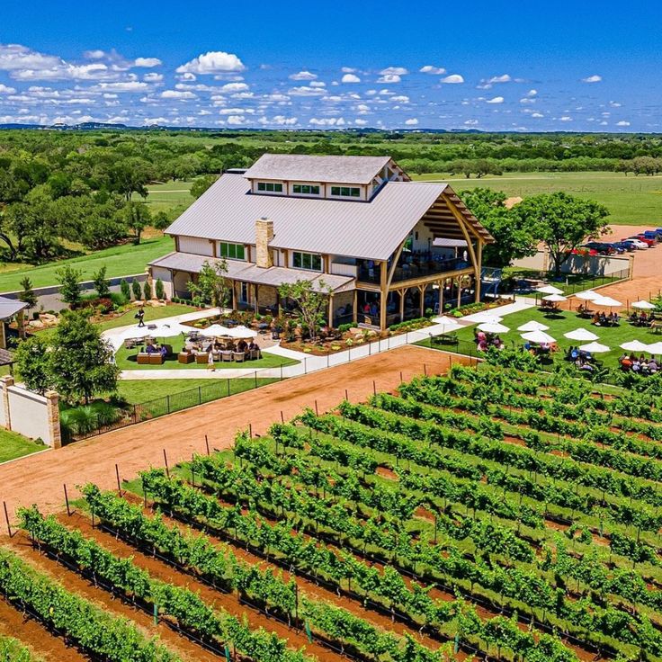 an aerial view of a farm house surrounded by trees