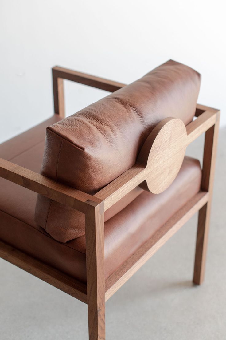 a brown leather couch sitting on top of a wooden frame