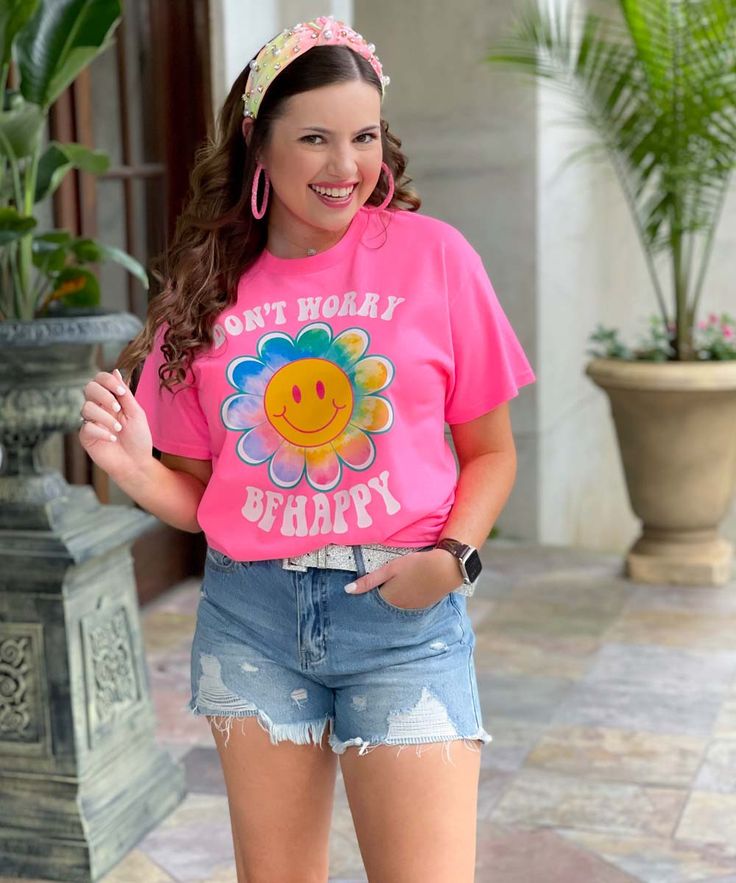 Introducing our Don't Worry Be Happy Flower Smiley Graphic Shirt, a vibrant and uplifting addition to your wardrobe that spreads positivity and joy wherever you go. This captivating shirt features a colorful design on a neon pink background, guaranteed to make a bold statement. The focal point of the design is a cheerful daisy with a smiley face center, radiating happiness and warmth. Encircling the flower are the words "Don't worry be happy," serving as a gentle reminder to embrace a positive m Playful Pink T-shirt For Spring, Playful Pink T-shirt With Slogan, Fun Slogan T-shirt For Spring, Spring Multicolor Slogan T-shirt, Playful Pink Relaxed Fit T-shirt, Playful Pink T-shirt With Graphic Print, Playful Pink Graphic Print T-shirt, Pink Letter Print T-shirt For Spring, Spring Pink T-shirt With Graphic Print