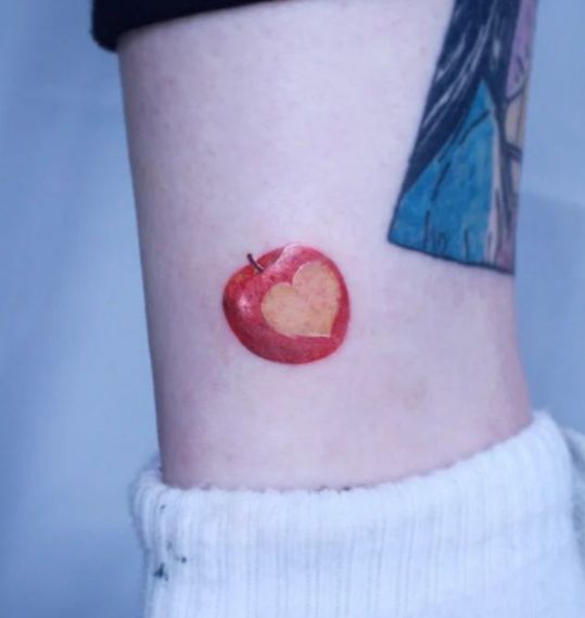 an apple with a heart painted on the side of its leg is seen in this image