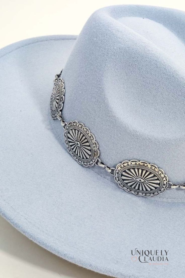 You know you need that one accessory to make all your favorite outfits shine with perfection. The Colorado Silver Medallion Chain Fedora Hat is chic and stylish, and it will definitely turn heads when you wear it. It features a gorgeous silver-tone medallion band, a tall crown design in a light grey (almost baby blue) color. 90% Polyester, and 10% Alloy Stiff Brim: 3.5" Crown: 4.75 Medallion Band Height: 1.5" 22" interior circumference with an internal drawstring Spot Clean Imported Western Silver Hats For Summer, Western Style Silver Hat With Flat Brim, Silver Curved Brim Hat For Summer, Summer Silver Hat With Curved Brim, Western Silver Hat Bands For Festivals, Western Style Silver Adjustable Hat Band, Silver Western Hat Bands For Festival, Western Adjustable Silver Hat Band, Elegant Silver Hat With Flat Brim