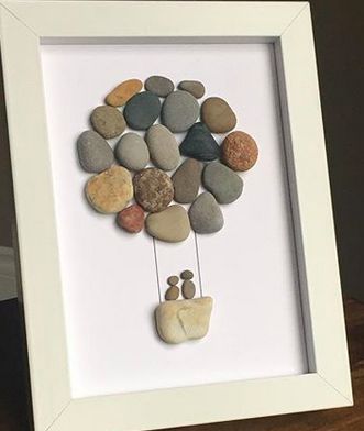 a white frame with rocks in the shape of a tree