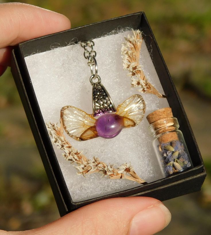 This silver resin coated pendant features an amethyst crystal bordered by two real cicada brood xix hindwings, and will come strung through a chain (color and length of your choice). Each wing used to create this mystical looking jewelry was ethically collected straight from the ground in Southern Illinois. Wearing this woodland necklace is a perfect way to keep a bit nature with you at all times of the year. You will receive the exact pendant as shown in the pictures. Small bubbles may be prese Bug Jewelry, Necklace Fairy, Insect Wings, Fairy Necklace, Southern Illinois, Jewelry Post, Botanical Jewelry, Amethyst Crystal, Resin Jewelry