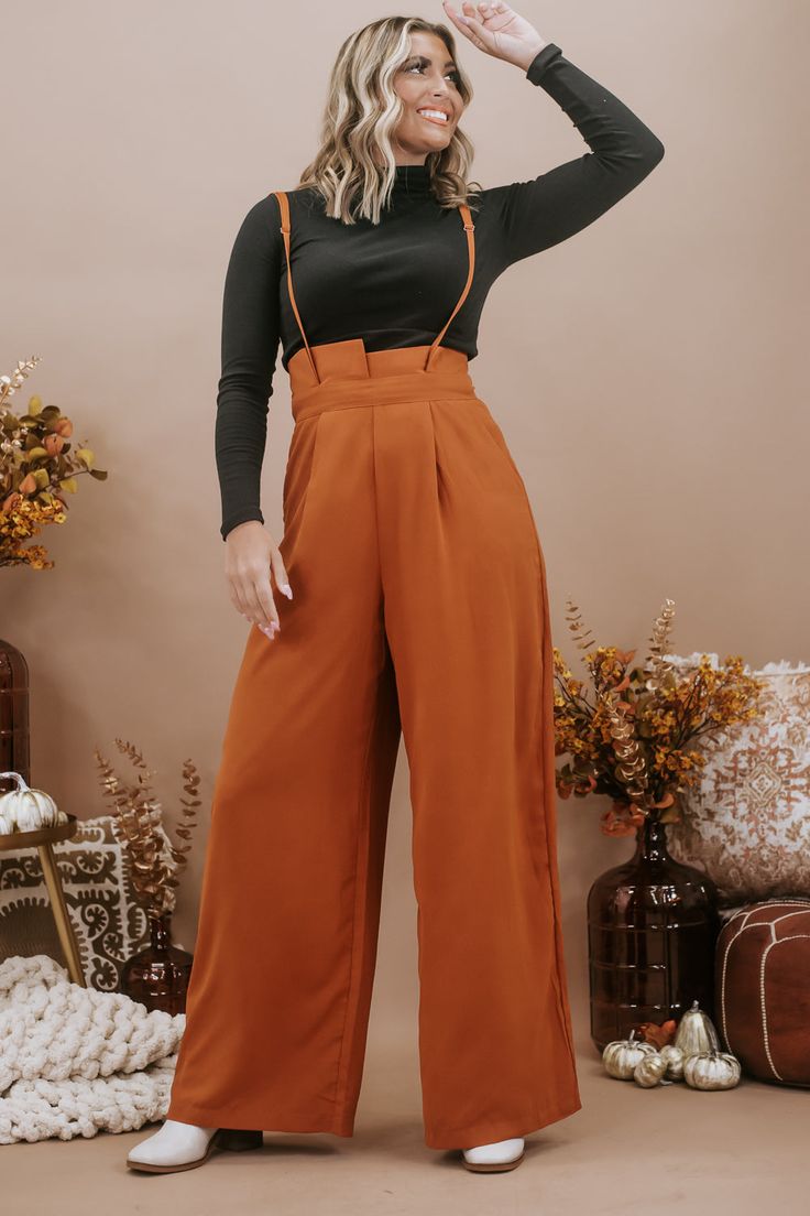 The Setting Trends Suspender Pants in Rust are a trendy and stylish choice for your wardrobe. These suspender pants are perfect for a 30-something mama who loves boutique fashion and wants to make a fashion statement. These pants are a surefire way to set trends and show off your fashion-forward style. Solid Paper Bag High-waist Wide Leg Suspender Pants Wide legs Full length Wide banded high waist Side hidden pockets Made in the USA Inseam: Small 30 in Medium 30.50 in Large 30.75 Rise: Small 15. Chic Fitted Bottoms With Suspenders, Trendy Fitted Bottoms With Suspenders, Chic Spring Bottoms With Suspenders, Wide Leg Bottoms With Suspenders For Summer, Summer Wide Leg Bottoms With Suspenders, Suspenders Jumpsuits And Rompers For Workwear In Fall, Fitted Bottoms With Suspenders For Spring, Fall High-waisted Workwear Jumpsuits And Rompers, Fall Wide Leg Workwear Jumpsuits And Rompers