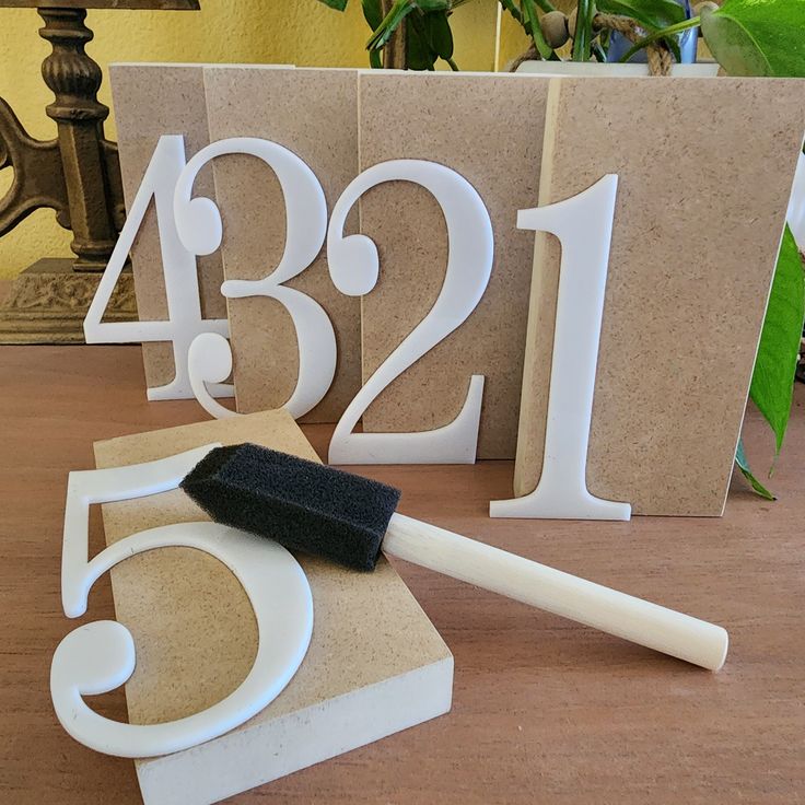 the number twenty five is placed next to a brush and some paper on a table