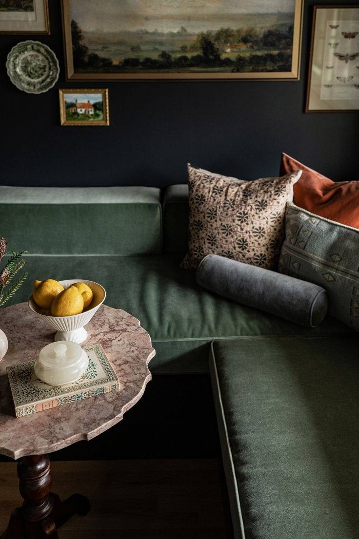 a green couch and table with fruit on it