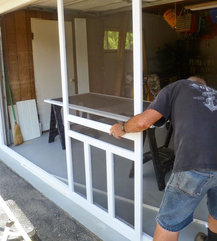 a man standing in front of a sliding glass door that is being installed on the side of a house