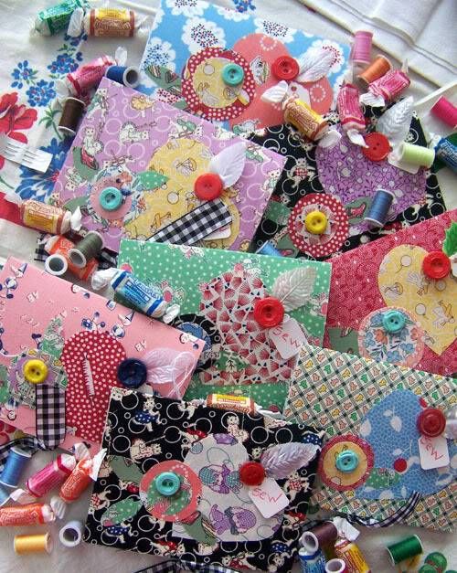 many different pieces of fabric and sewing thread on a white tablecloth with colorful buttons