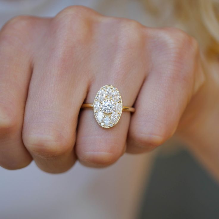 a woman's hand wearing a yellow gold ring with two round diamonds on it