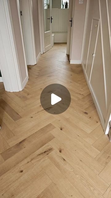 an empty hallway with wooden floors and white walls