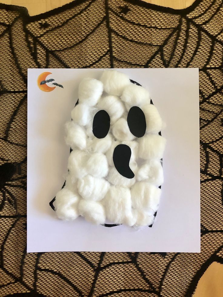 a white paper with black polka dots and a ghost made out of fake cotton balls