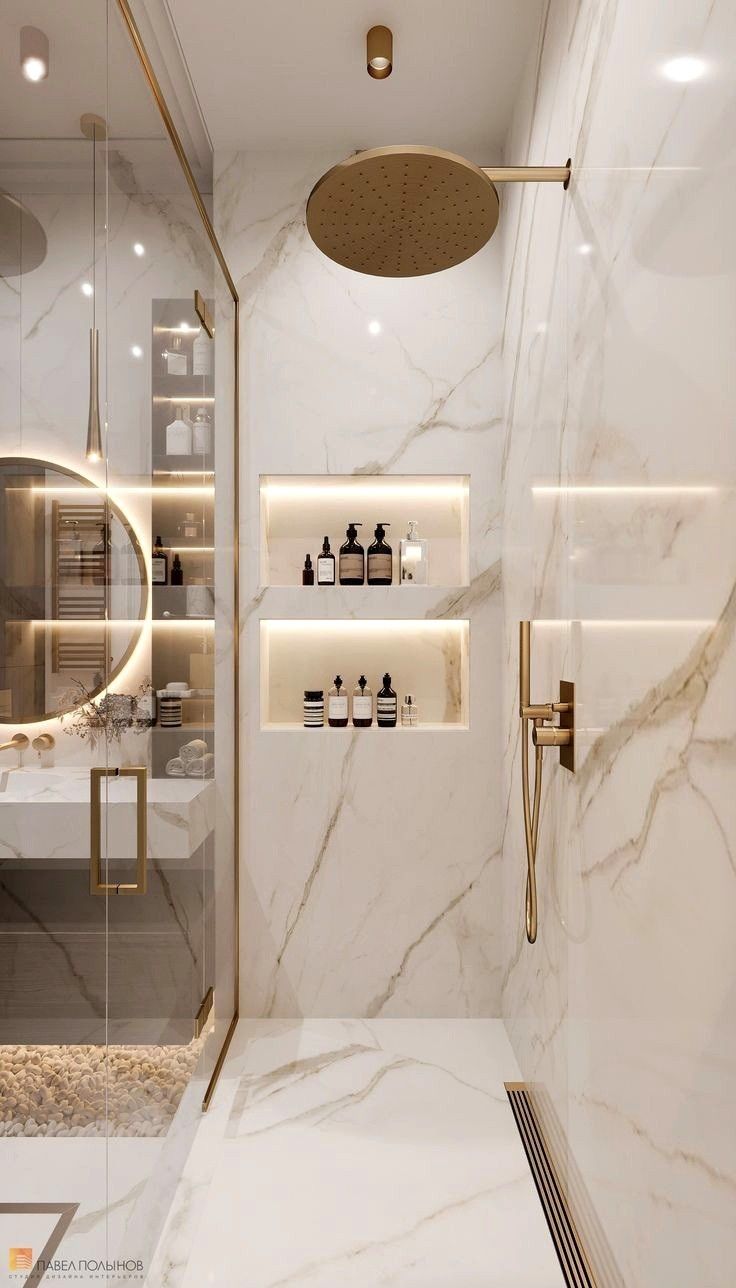 a bathroom with marble walls and flooring, lighted by recessed lighting in the shower area