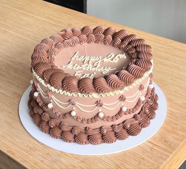 a chocolate birthday cake sitting on top of a wooden table