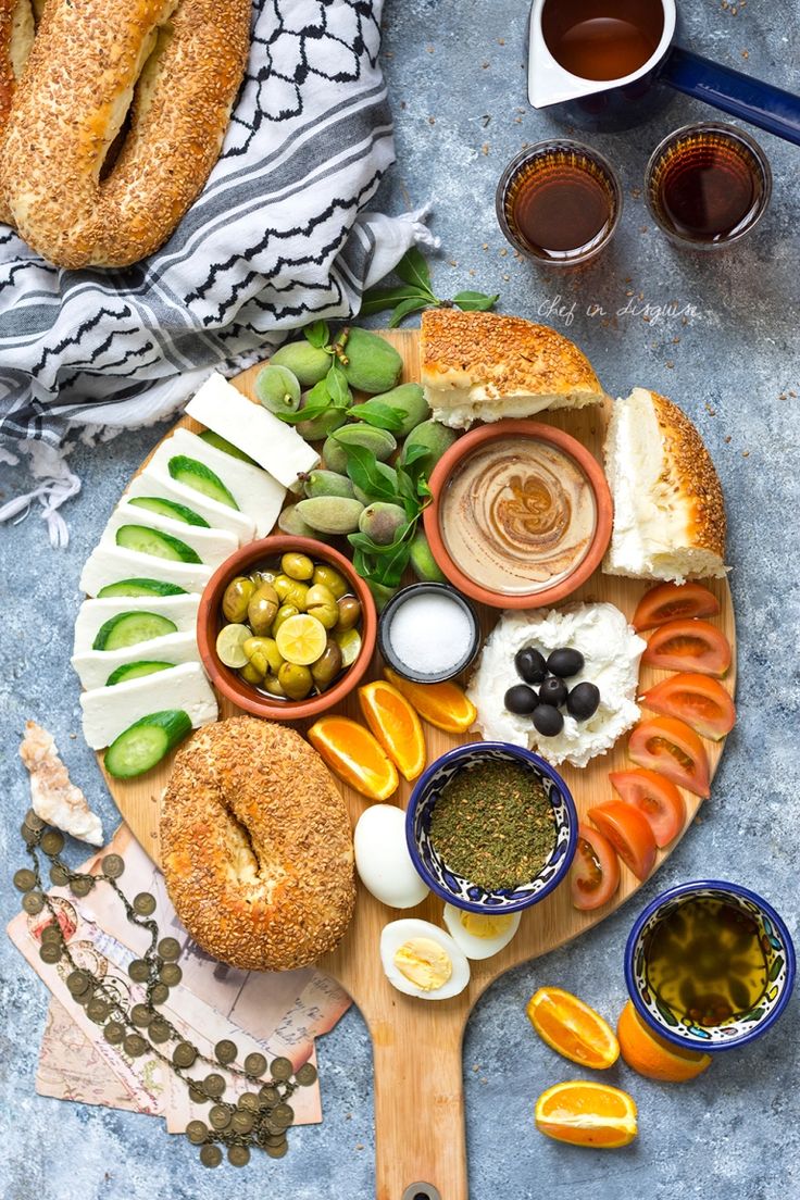 an assortment of breads, olives, and other foods on a cutting board