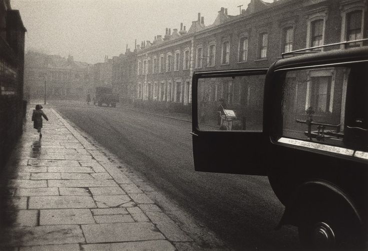 a black and white photo of a person walking down the street