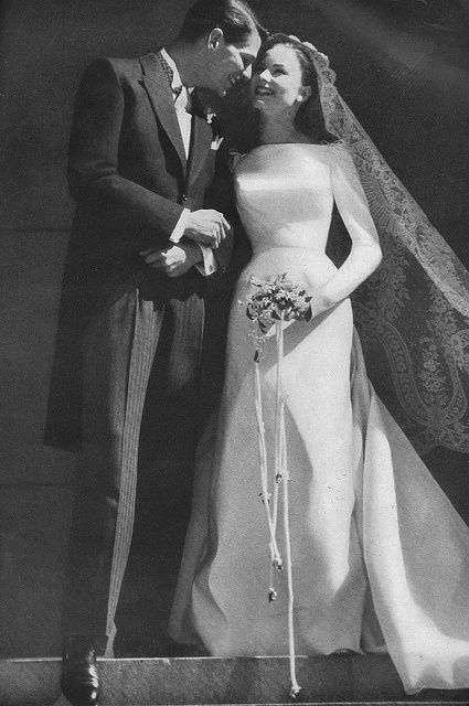 an old black and white photo of a bride and groom standing next to each other