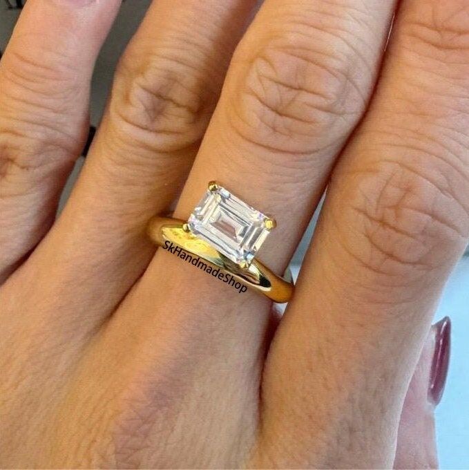 a woman's hand with a ring on it and a diamond in the middle