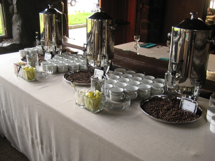 there are many cups and bowls on the table with coffee beans in front of them